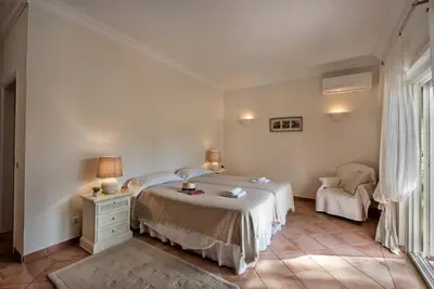 a white bedroom with a bed and a chair at Villa Zarana fantastic house in Salinas in Faro