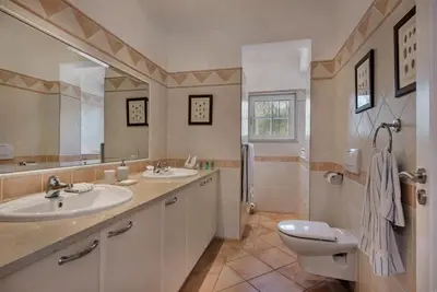 a bathroom with two sinks and a toilet and a shower at Villa Zarana fantastic house in Salinas in Faro