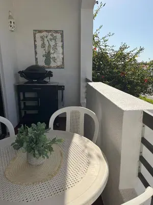 a white table and chairs with a plant on a balcony at Apartamento Diago in Albufeira