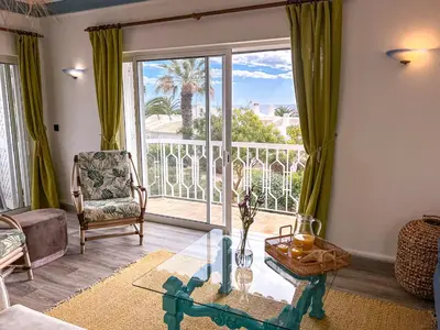 a living room with a glass table and a large window at Lovely Apartment in Albufeira 2BD 250m Beach Ocean view and AC Wi-Fi Pool in Albufeira