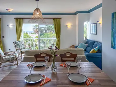 a living room with a table and a couch at Lovely Apartment in Albufeira 2BD 250m Beach Ocean view and AC Wi-Fi Pool in Albufeira