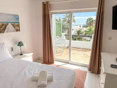 a bedroom with a bed and a view of a patio at Lovely Apartment in Albufeira 2BD 250m Beach Ocean view and AC Wi-Fi Pool in Albufeira