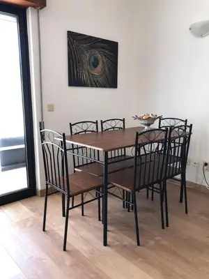 a dining room table with chairs and a painting on the wall at Cozy apartment near Oura Beach in Albufeira