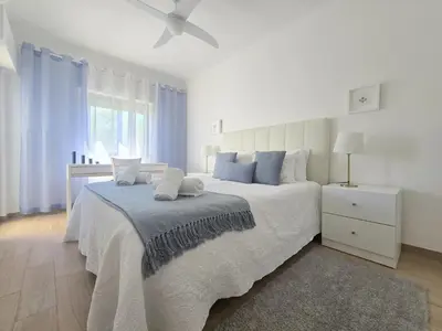 a bedroom with a bed and a ceiling fan at Modern Beach Apartment - Avenida Mar 1 - 150 mts da praia in Quarteira
