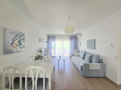 a park with a bench and trees and buildings at Modern Beach Apartment - Avenida Mar 1 - 150 mts da praia in Quarteira