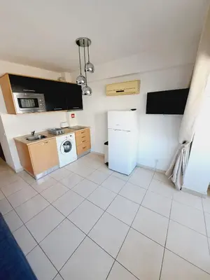 a kitchen with a refrigerator and a washing machine at T1, proche plage et commerces in Quarteira