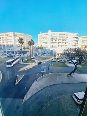 a view of a parking lot with a large building at T1, proche plage et commerces in Quarteira