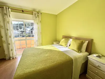 a bedroom with a bed with yellow walls and a window at Vila Caravela - Private Pool by HD Properties in Vilamoura