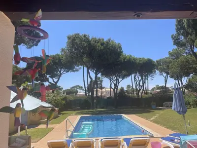 a swimming pool in a yard with chairs around it at Vila Caravela - Private Pool by HD Properties in Vilamoura