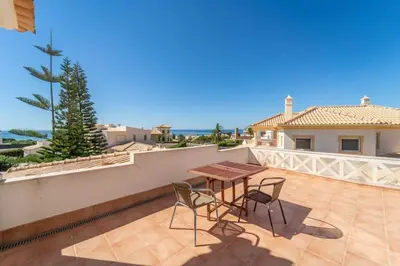 a patio with a table and chairs on a balcony at Villa Gale Grande - bright airy property with a private pool in Albufeira