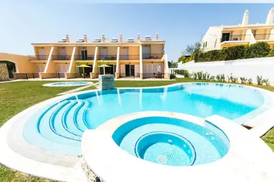 a large swimming pool in front of a building at Apartment Filipa III - Beachfront with Jacuzzi in Albufeira
