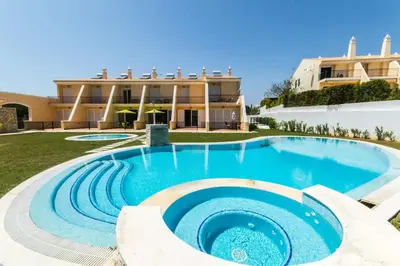 a swimming pool in front of a building at Apartment Filipa III - Beachfront with Jacuzzi in Albufeira
