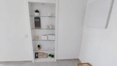 a room with white walls and shelves with plants at Apartamento Kélyfos Beach by feriascomsol in Quarteira