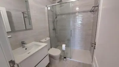 a bathroom with a shower and a toilet and a sink at Apartamento Kélyfos Beach by feriascomsol in Quarteira