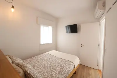 a white bedroom with a bed and a window at Downtown Villa in Faro