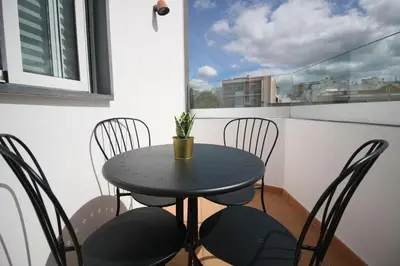 a small black table and chairs on a balcony at Downtown Villa in Faro