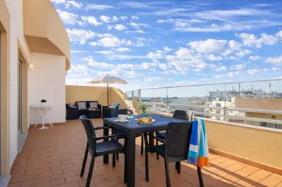 a patio with a table and chairs on a balcony at Apartamento Alameda in Quarteira