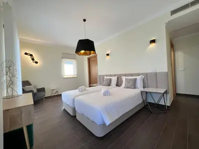 a bedroom with a large white bed and a couch at Villa Pedra Luxe - Spacious modern villa in Albufeira