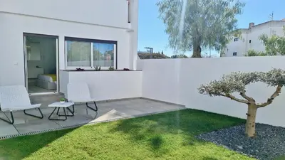 a white house with two chairs and a tree at Marina Retreat - CleverDetails, for 2 adults and 2 children, Jacuzzi, near the Marina and the beach in Vilamoura