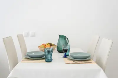 a dining room table with a white table with chairs and a white table clothurrency at CORTEZ - Vilamoura in Vilamoura