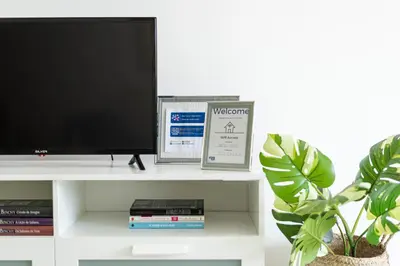 a television on a white shelf with a plant at CORTEZ - Vilamoura in Vilamoura
