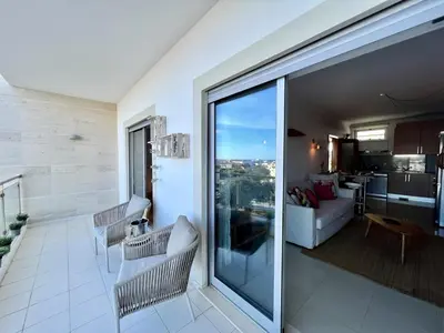 a living room with a large sliding glass door at Albufeira Forest View With Pool by Homing in Albufeira