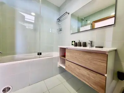 a bathroom with a sink and a tub and a mirror at Albufeira Forest View With Pool by Homing in Albufeira