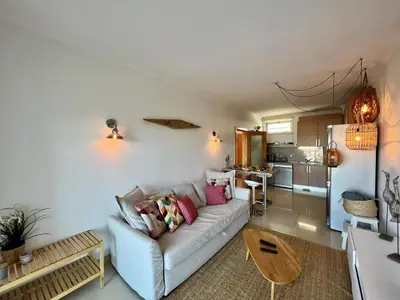 a living room with a couch and a kitchen at Albufeira Forest View With Pool by Homing in Albufeira