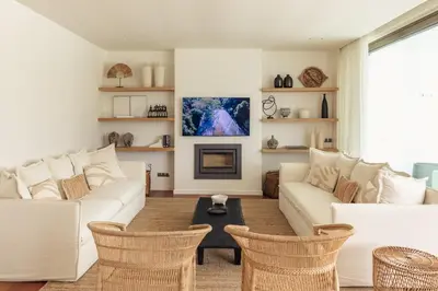 a living room with a white couch and a fireplace at Luxury Beach Villa - Casa do Forte- Infinity Pool sea view- Beach walking distance by DreamvillasAlbufeira in Albufeira