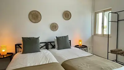 two beds in a bedroom with two lamps on the wall at Falesia by Check-in Portugal in Albufeira