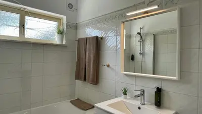 a bathroom with a sink and a mirror and a tub at Falesia by Check-in Portugal in Albufeira