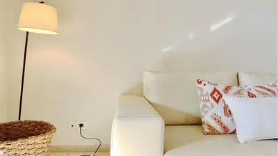 a white couch with pillows sitting next to a lamp at Los Olivos Del Golf 249- CleverDetails, Sleeps 6 Adults 1 Child in Vilamoura