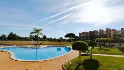 a large swimming pool with trees and a building at Los Olivos Del Golf 249- CleverDetails, Sleeps 6 Adults 1 Child in Vilamoura