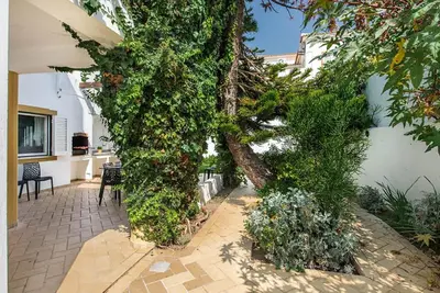 a large ivy covered tree in a courtyard at Villa Almanda - Spacious villa perfectly located between Albufeira Marina and the Old Town in Albufeira