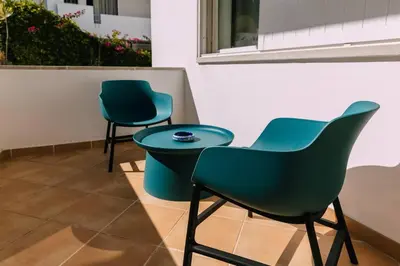 three chairs and a table in a room at Starry Nights Apartment in Albufeira