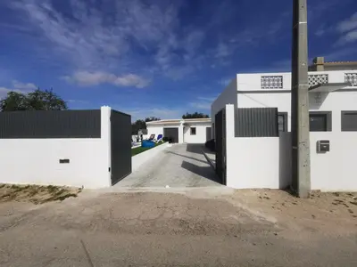 a living room with a flat screen tv on a wall at Casas Caiado Two Houses with swimming POOL in Faro