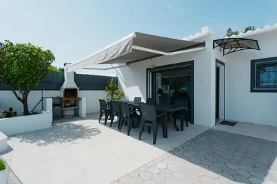 three chairs and a table in front of a white wall at Casas Caiado Two Houses with swimming POOL in Faro
