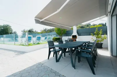 two chairs and a table next to a swimming pool at Casas Caiado Two Houses with swimming POOL in Faro