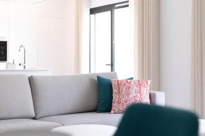 a living room with a gray couch with a colorful pillow at Orange Boutique Residence - Casa Luis Camões in Quarteira