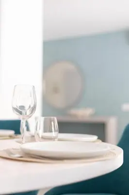 a table with white plates and wine glasses on it at Orange Boutique Residence - Casa Luis Camões in Quarteira