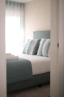 a bedroom with a bed with blue and white pillows at Orange Boutique Residence - Casa Luis Camões in Quarteira