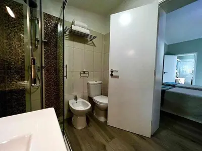 a bathroom with a toilet and a sink and a shower at Green House by FHR estacionamento e WI-FI in Quarteira