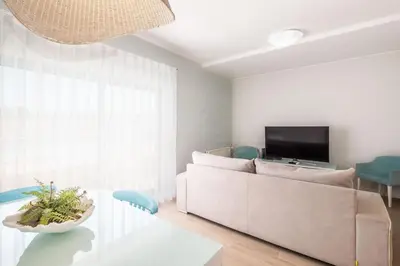 a living room with a couch and a flat screen tv at Al Marina View Uma - Lux apartment on the marina in Páteo