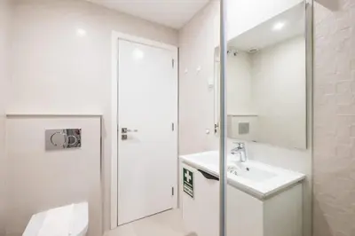 a white bathroom with a sink and a mirror at Al Marina View Uma - Lux apartment on the marina in Páteo