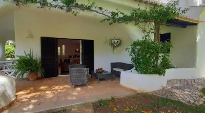 a house with a potted tree in the courtyard at Villa Pinhal- Beautiful Villa located in quiet area in Quarteira