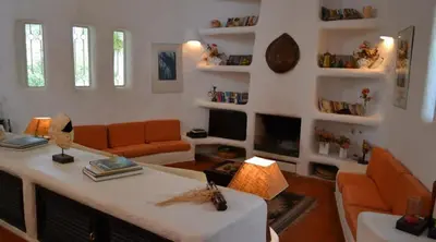a living room with an orange couch and a table at Villa Pinhal- Beautiful Villa located in quiet area in Quarteira