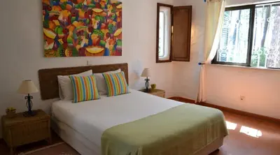 a bedroom with a bed and a painting on the wall at Villa Pinhal- Beautiful Villa located in quiet area in Quarteira