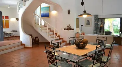 a living room with a table and a staircase at Villa Pinhal- Beautiful Villa located in quiet area in Quarteira