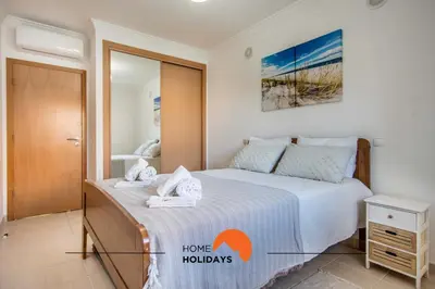 a bedroom with a bed and a mirror at #123 T2 Pão das Areias by Home Holidays in Albufeira