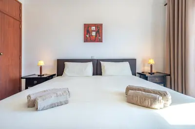 a bedroom with a large white bed with two night stands at AlgarSun - idealy situated holiday apartment with all modern comfort in Albufeira